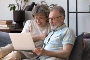 Happy,Bonding,Mature,Older,Family,Couple,Looking,At,Laptop,Screen,